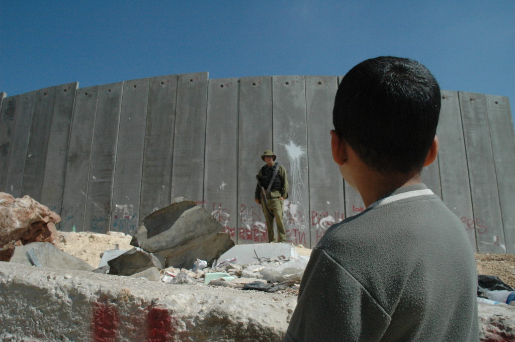 Boy_and_soldier_in_front_of_Israeli_wall